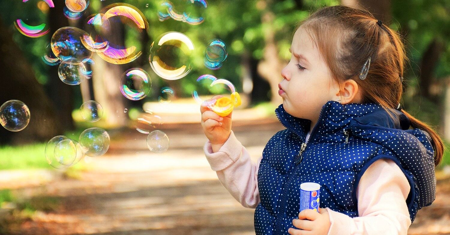 Kinder entwickeln sich - kleines Mädchen lernt Seifenblasen zu pusten