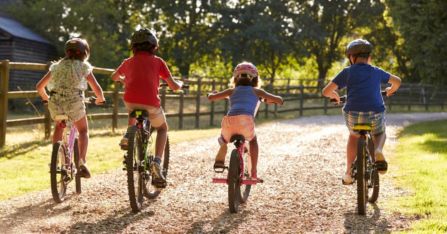Drei Kinder fahren Fahrrad: alle drei tragen Fahrradhelme