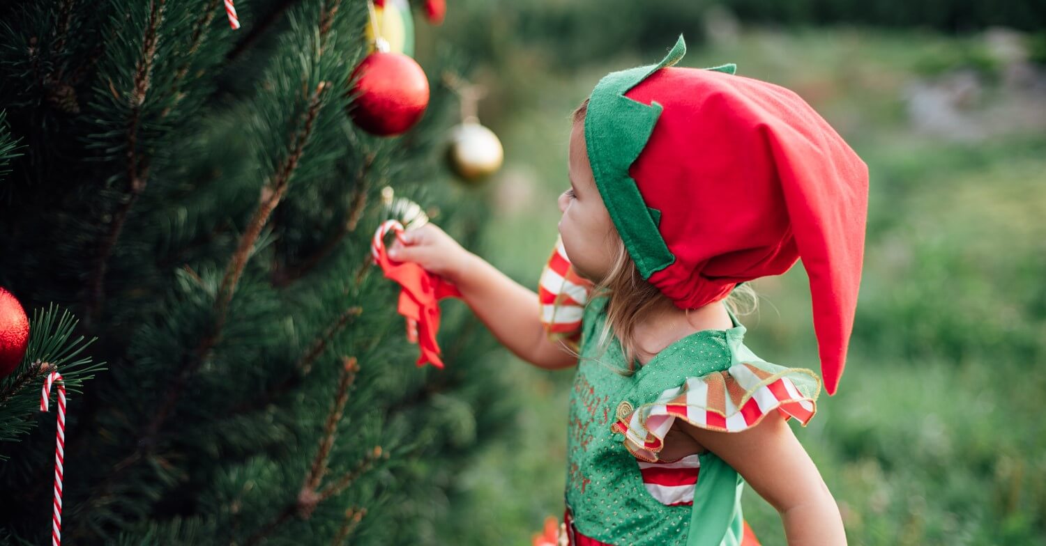 Weihnachtselfe mit rowei geringelten Kniestrümpfen schmückt den Weihnachtsbaum